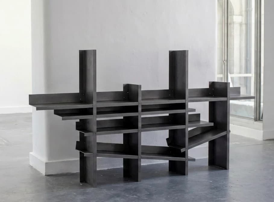 A wide asymmetric steel shelving study with stepped uprights and intersecting shelf levels.